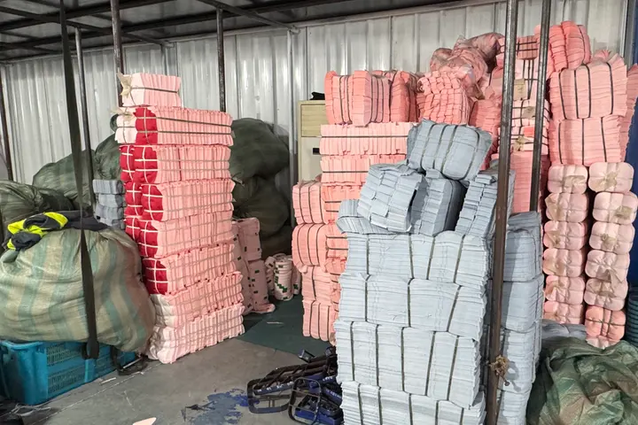 Colour-sorted stacks of cut backpack panels