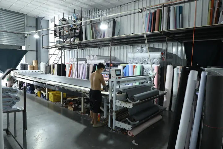 Fabric rolls staged beside the spreading machine in the Senszx cutting room