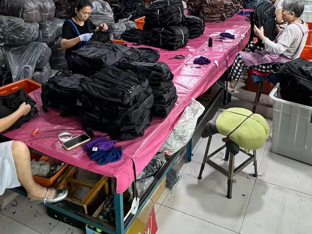 QC inspector checking the zipper run on a finished backpack