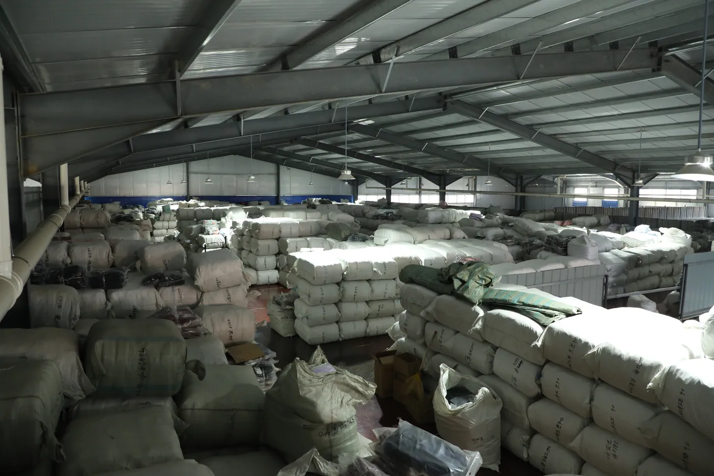Baled and palletised finished backpacks staged at the loading bay