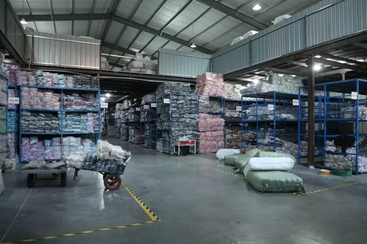 Staff counting racked finished backpacks in the Senszx warehouse before loading